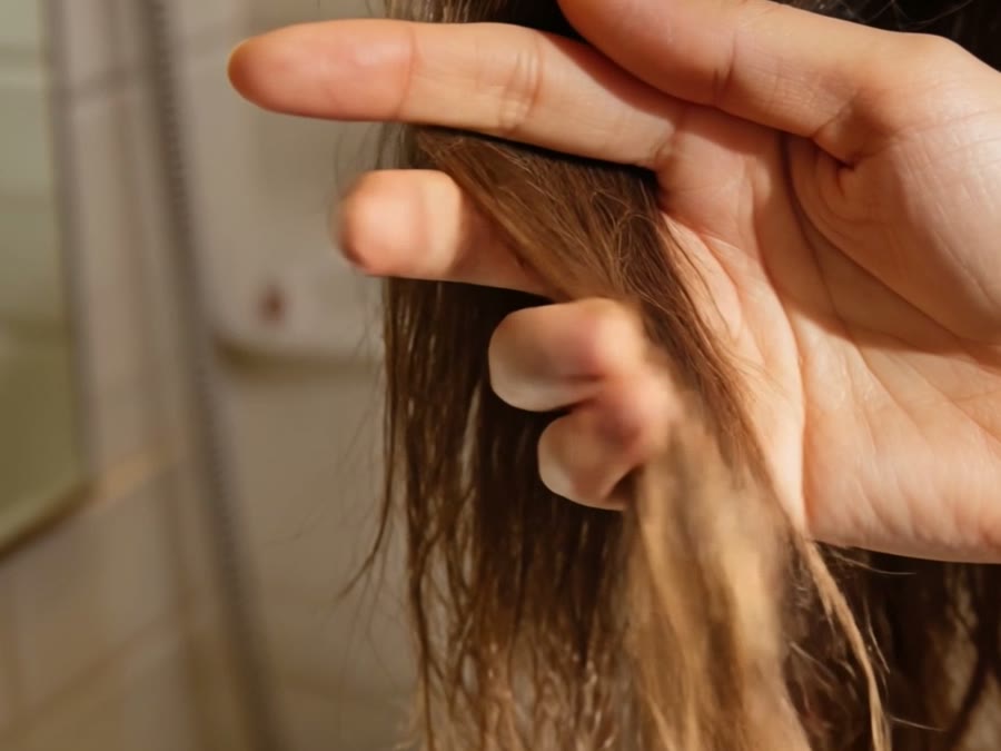 Mano pasando por el largo del pelo