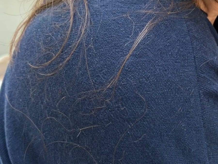 Pelos sueltos sobre un jersey azul marino